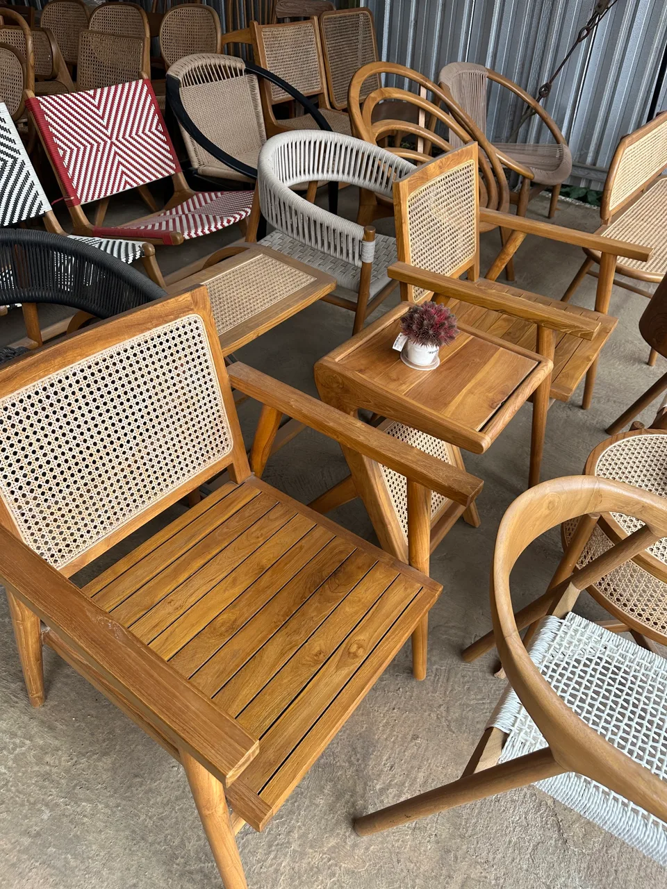 Cane-back lounge armchair with slatted seat among chairs in the workshop