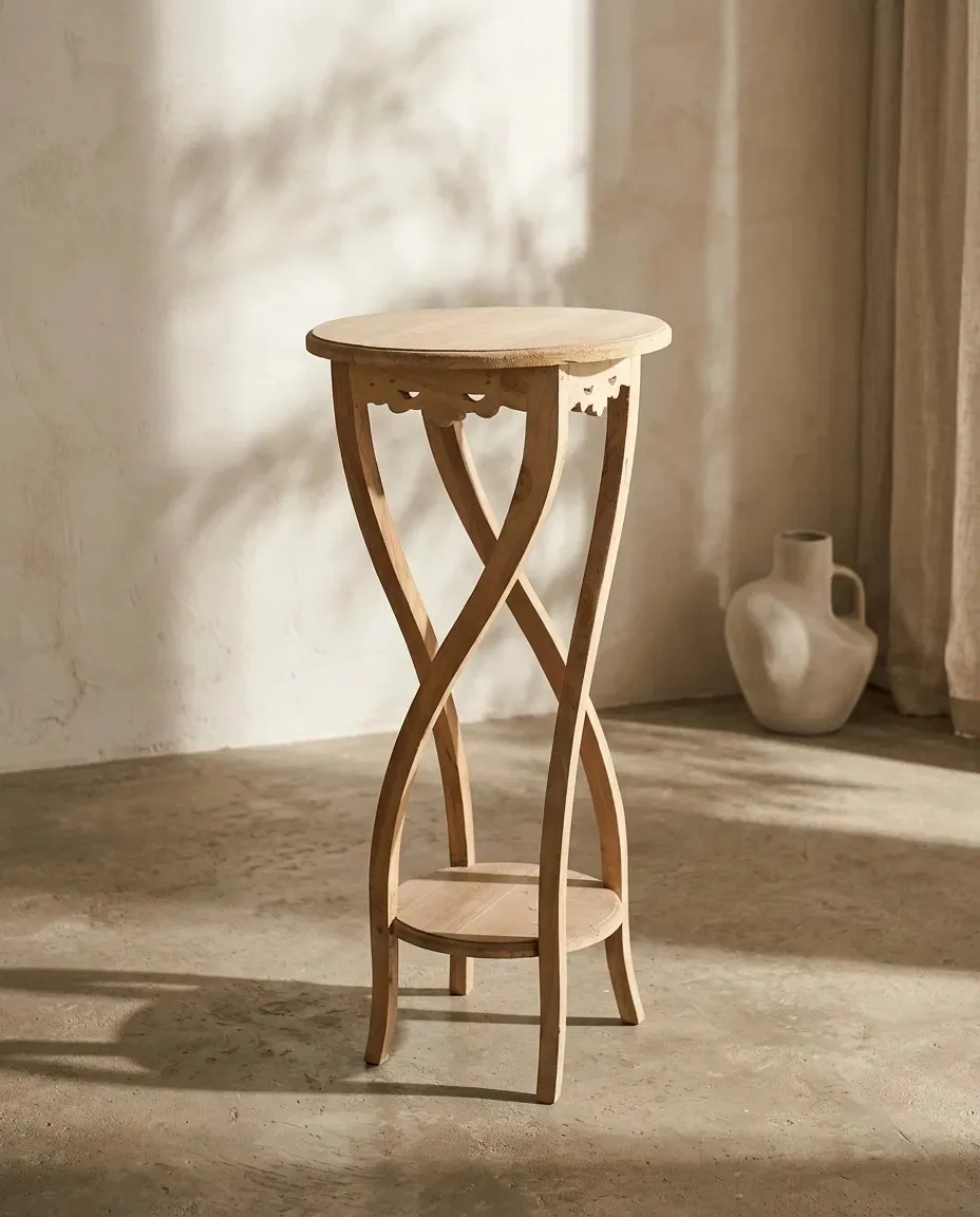 Pedestal table beside a white jug in warm light