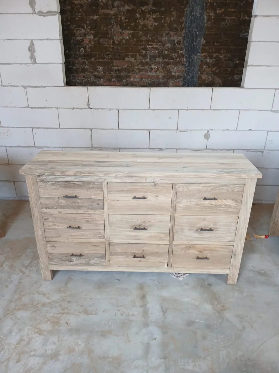 Nine-drawer solid teak chest with dark metal pulls in the workshop